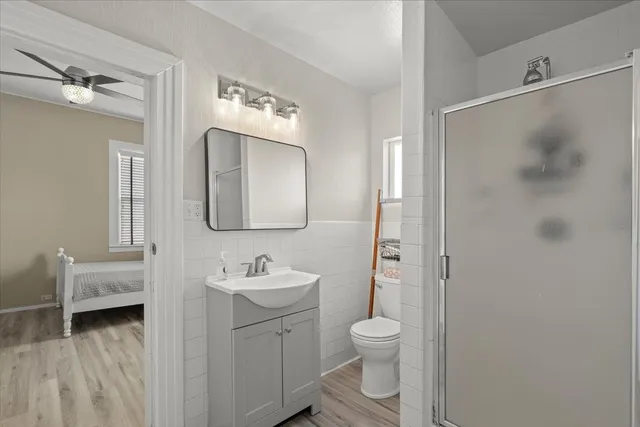 a bathroom with a toilet sink a mirror and shower