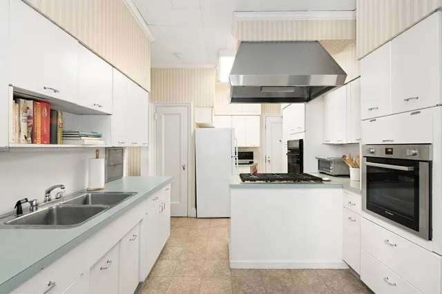 a kitchen with stainless steel appliances a stove a sink and a microwave