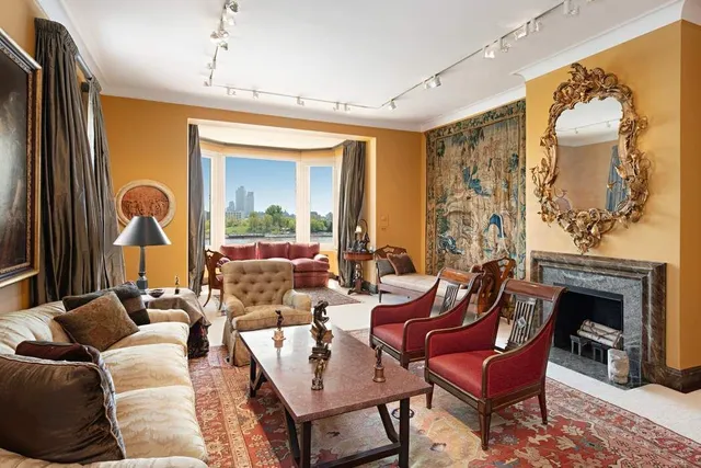 a living room with furniture a fireplace and a chandelier