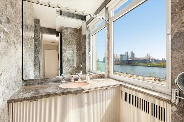 a bathroom with a granite countertop sink and a large mirror