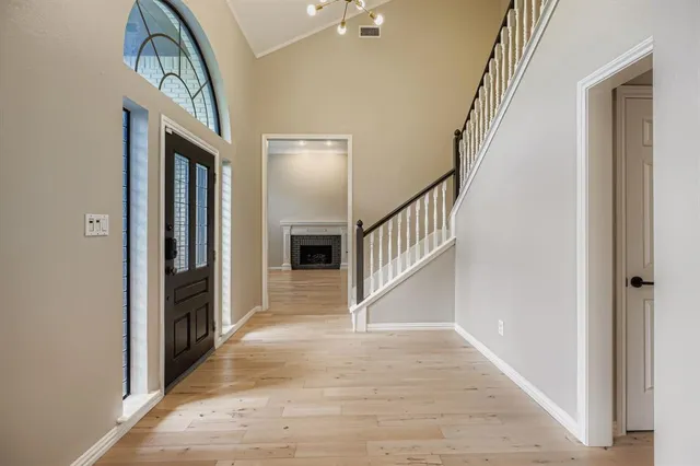 a view of a hallway with wooden floor and staircase