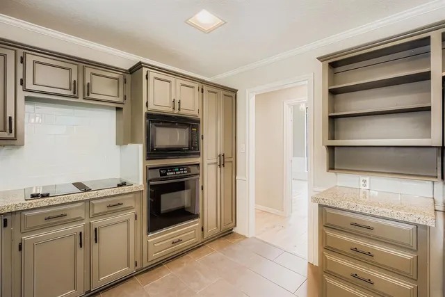 a kitchen with white cabinets and appliances