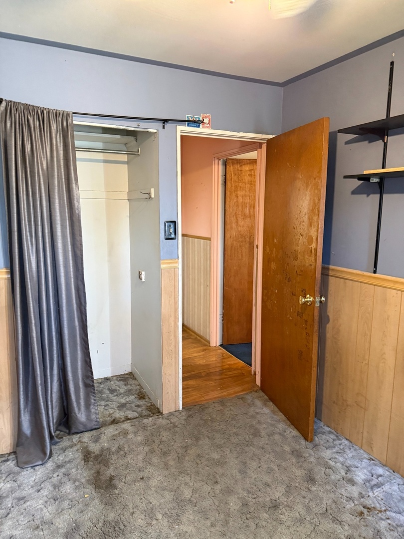 17226 Community Street Lansing, IL 60438 - Photo 12 of 25 an empty room with wooden floor and a sliding door