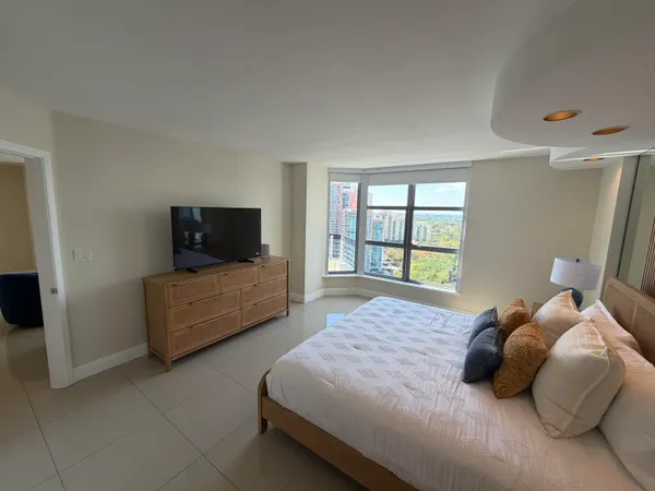 a bedroom with a bed and a television