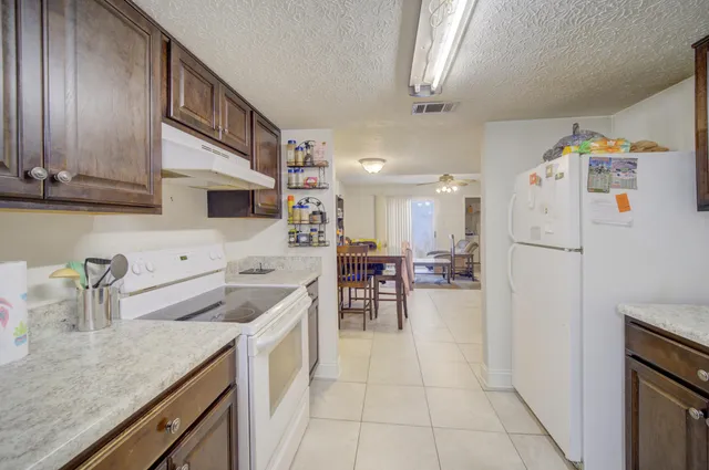 a kitchen with a sink a refrigerator and cabinets