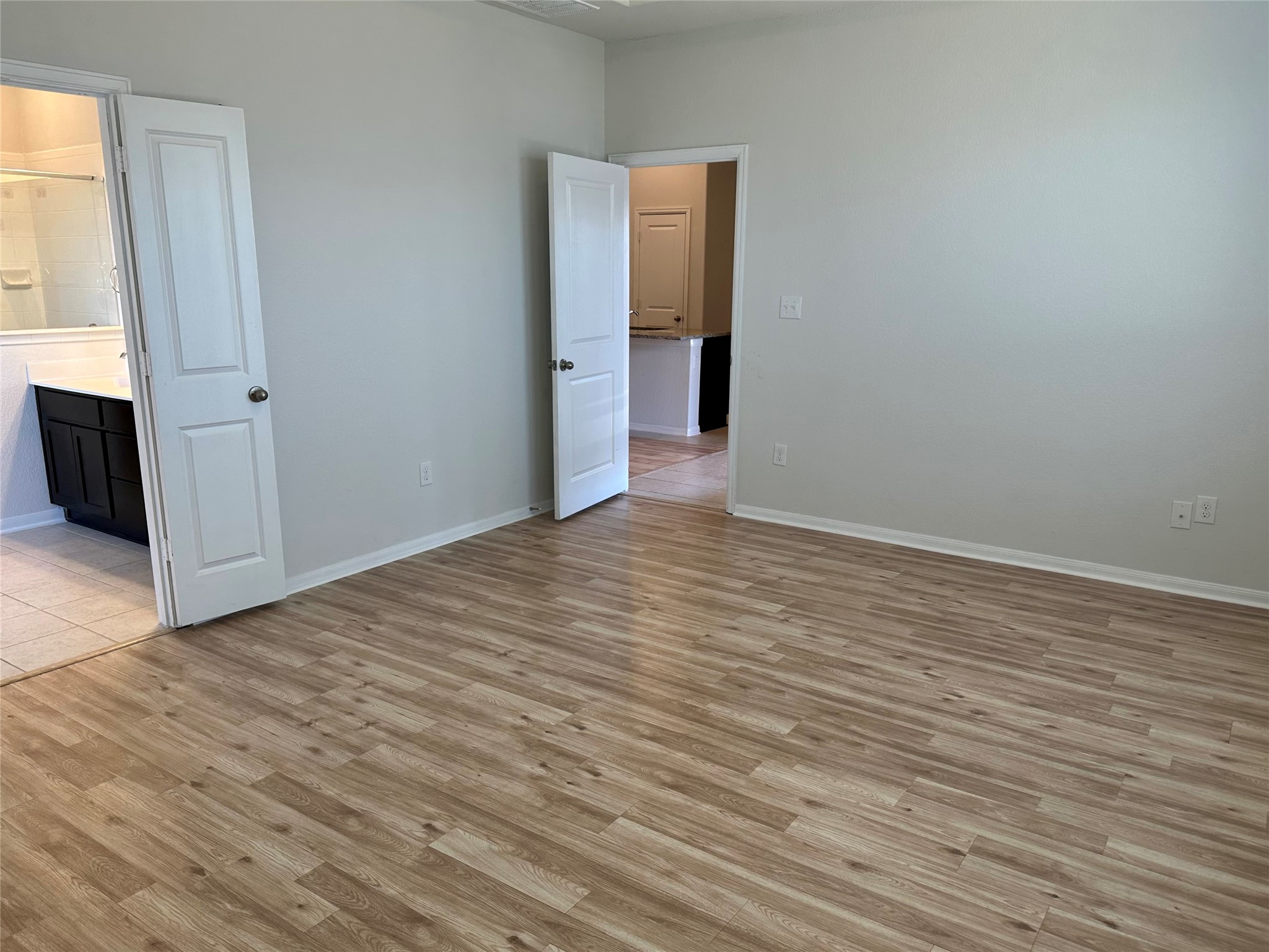 1003 Cherrystone Loop Buda, TX 78610 - Photo 11 of 27 a view of an empty room with wooden floor and a window