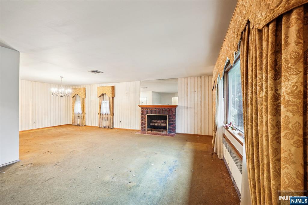 84 Squaw Brook Road North Haledon, NJ 07508 - Photo 4 of 23 a view of an empty room with a fireplace and a window