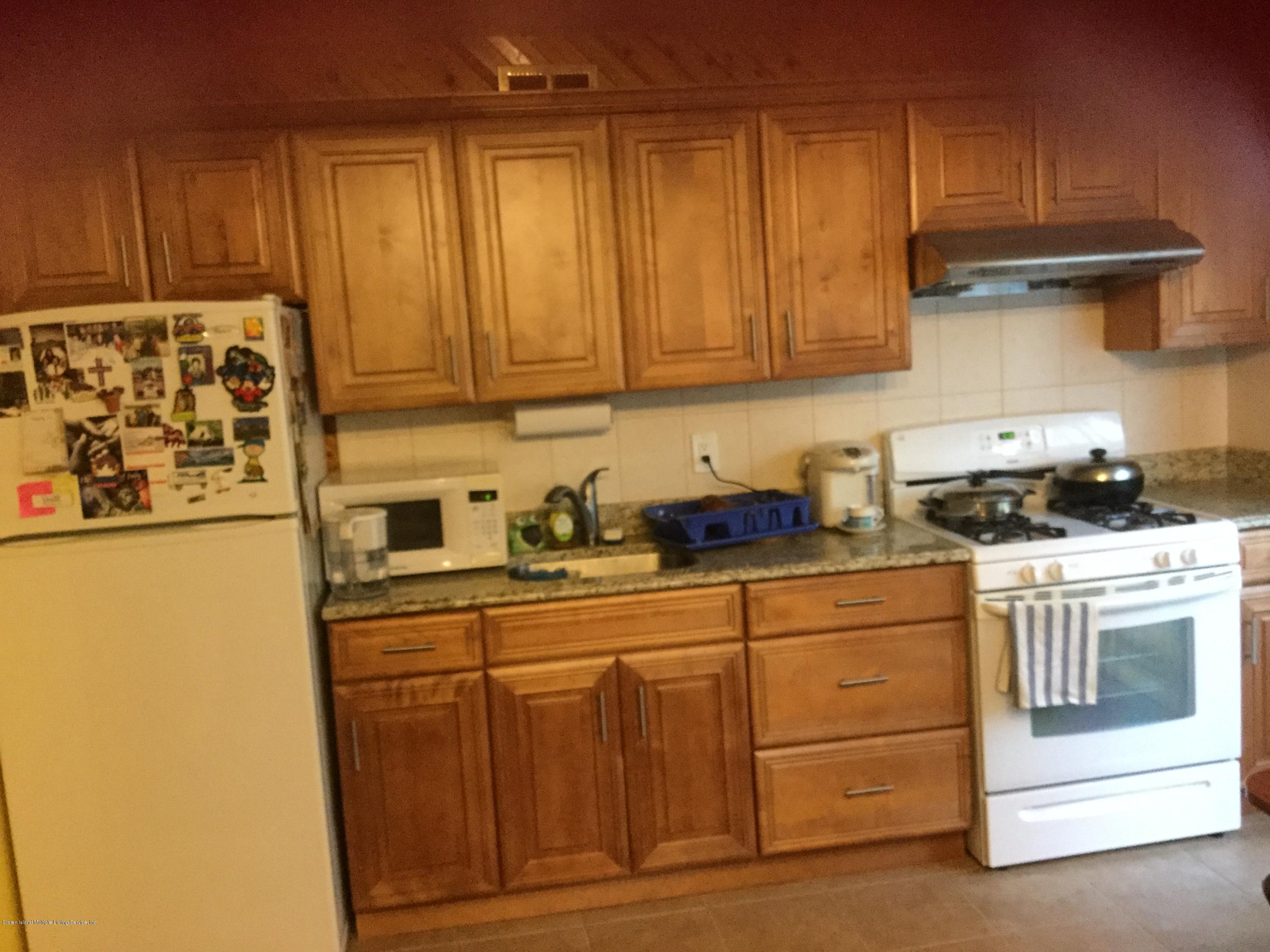 131 Green Valley Road Staten Island, NY 10312 - Photo 2 of 3 a kitchen with stainless steel appliances granite countertop a refrigerator a stove and a cabinets
