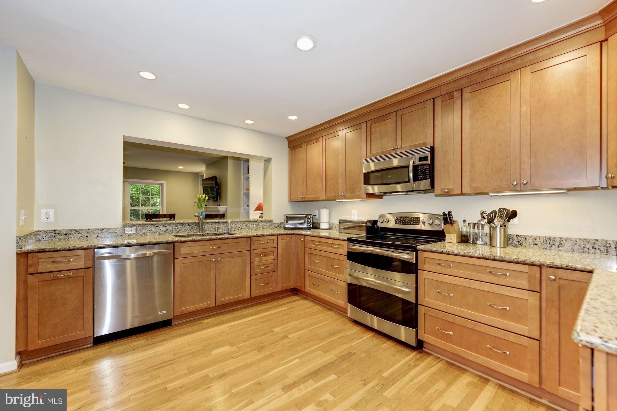 11603 Clipstone Lane Reston, VA 20191 - Photo 4 of 30 a kitchen with stainless steel appliances granite countertop a stove a sink and a microwave