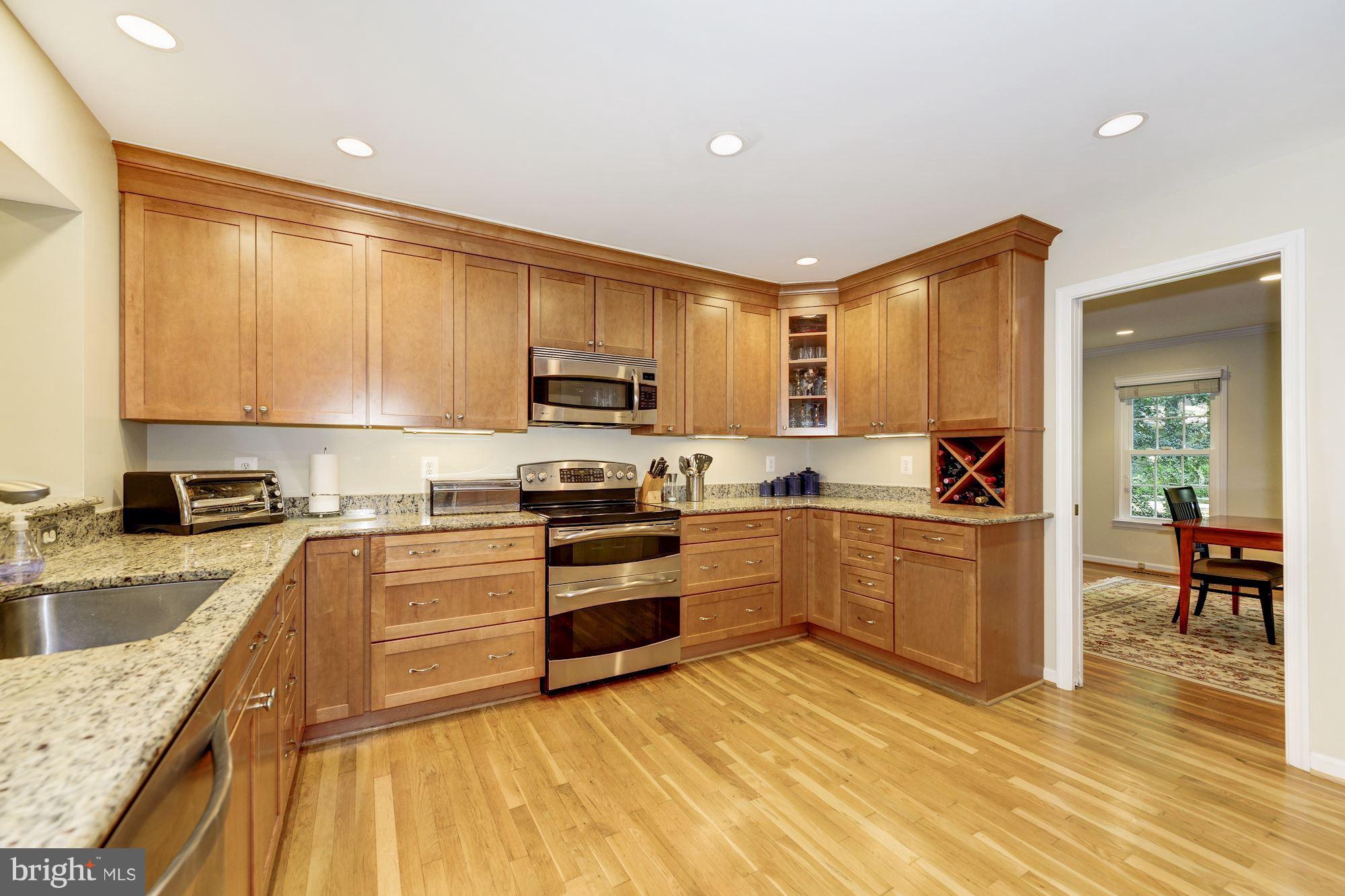 11603 Clipstone Lane Reston, VA 20191 - Photo 6 of 30 a kitchen with stainless steel appliances granite countertop a stove top oven a sink dishwasher a refrigerator and cabinets with wooden floor
