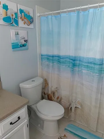 a bathroom with a toilet and a shower curtain
