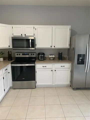 a kitchen with granite countertop a stove top oven and cabinets