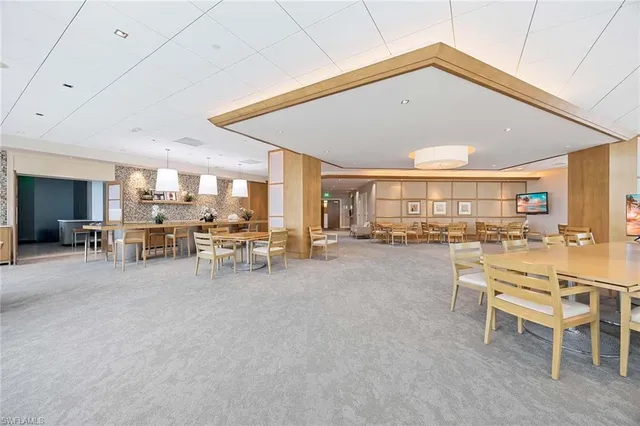 a view of a dining hall with furniture and a large window