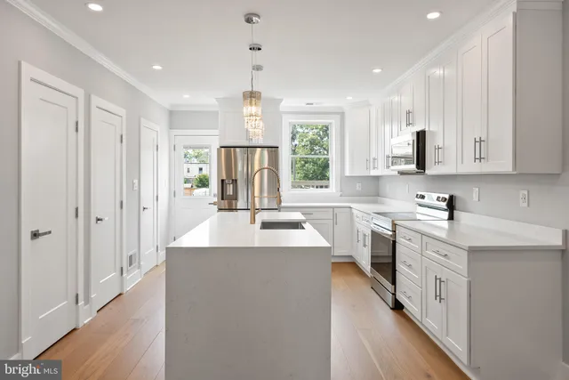 a kitchen with stainless steel appliances a stove refrigerator sink and microwave