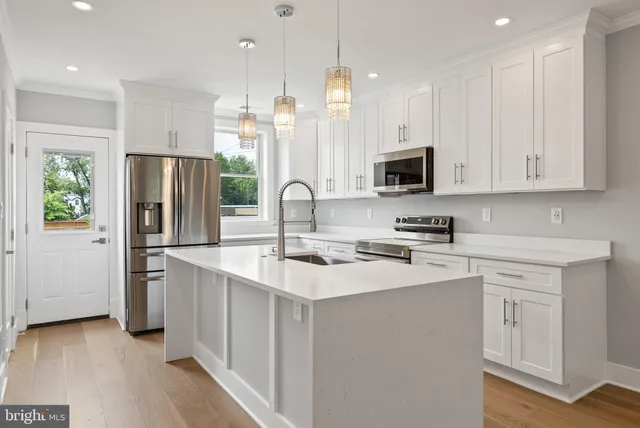 a kitchen with granite countertop a sink a stove and cabinets