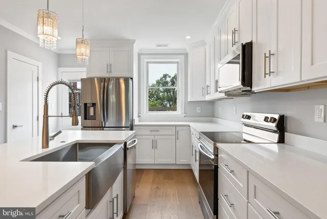 a kitchen that has a sink a stove and a wooden floor