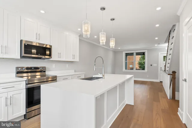 a kitchen with white cabinets and black appliances