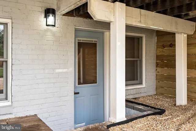 a view of a brick house with many windows and a yard