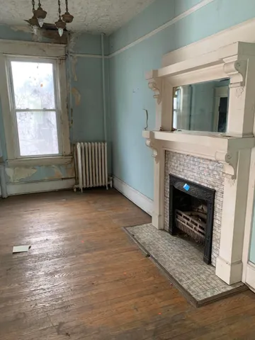 a living room with a fireplace windows and a rug