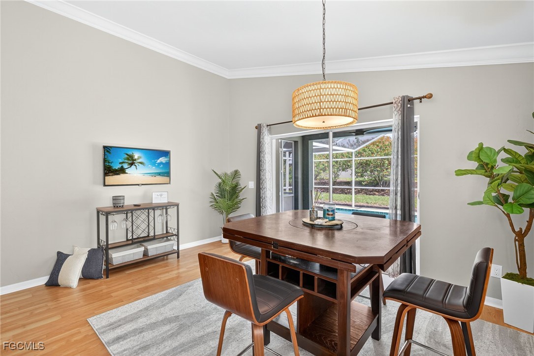 17974 Oakmont Ridge Circle Fort Myers, FL 33967 - Photo 7 of 35 a dining room with wooden floor a chandelier a wooden table and chairs
