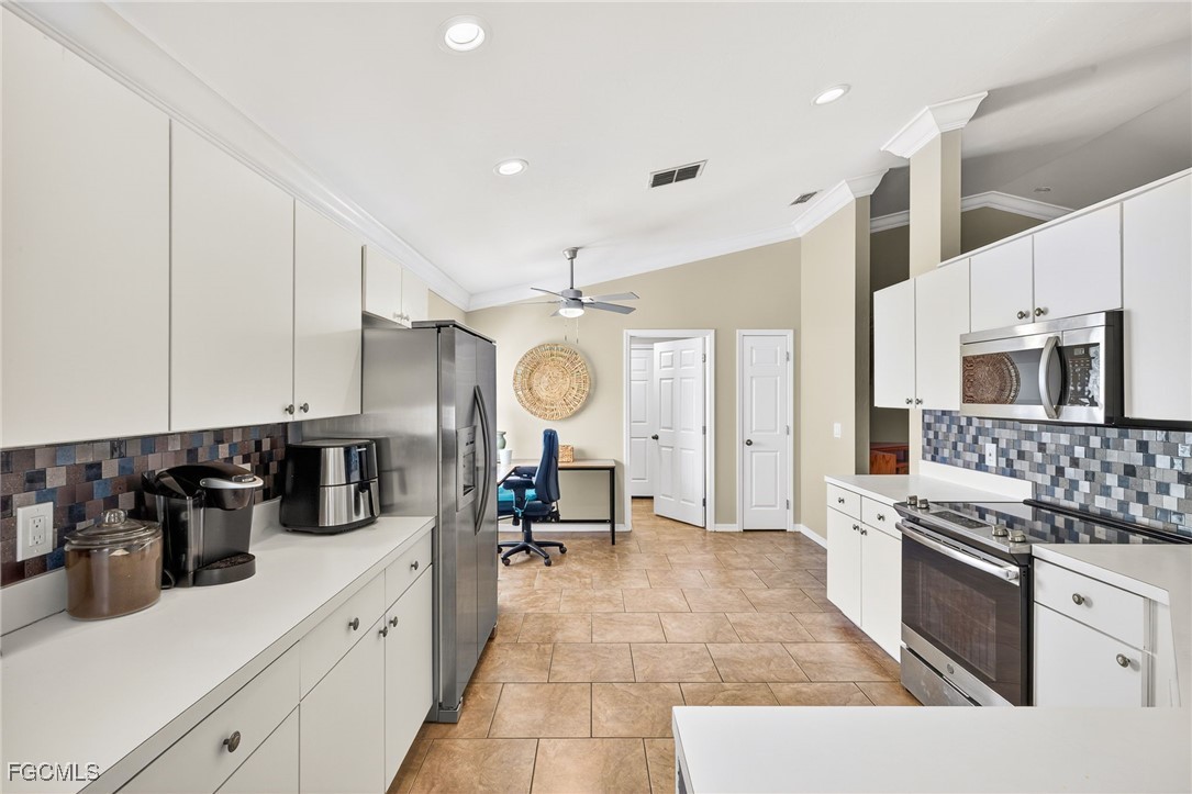 17974 Oakmont Ridge Circle Fort Myers, FL 33967 - Photo 10 of 35 a kitchen with stainless steel appliances a sink a stove and cabinets