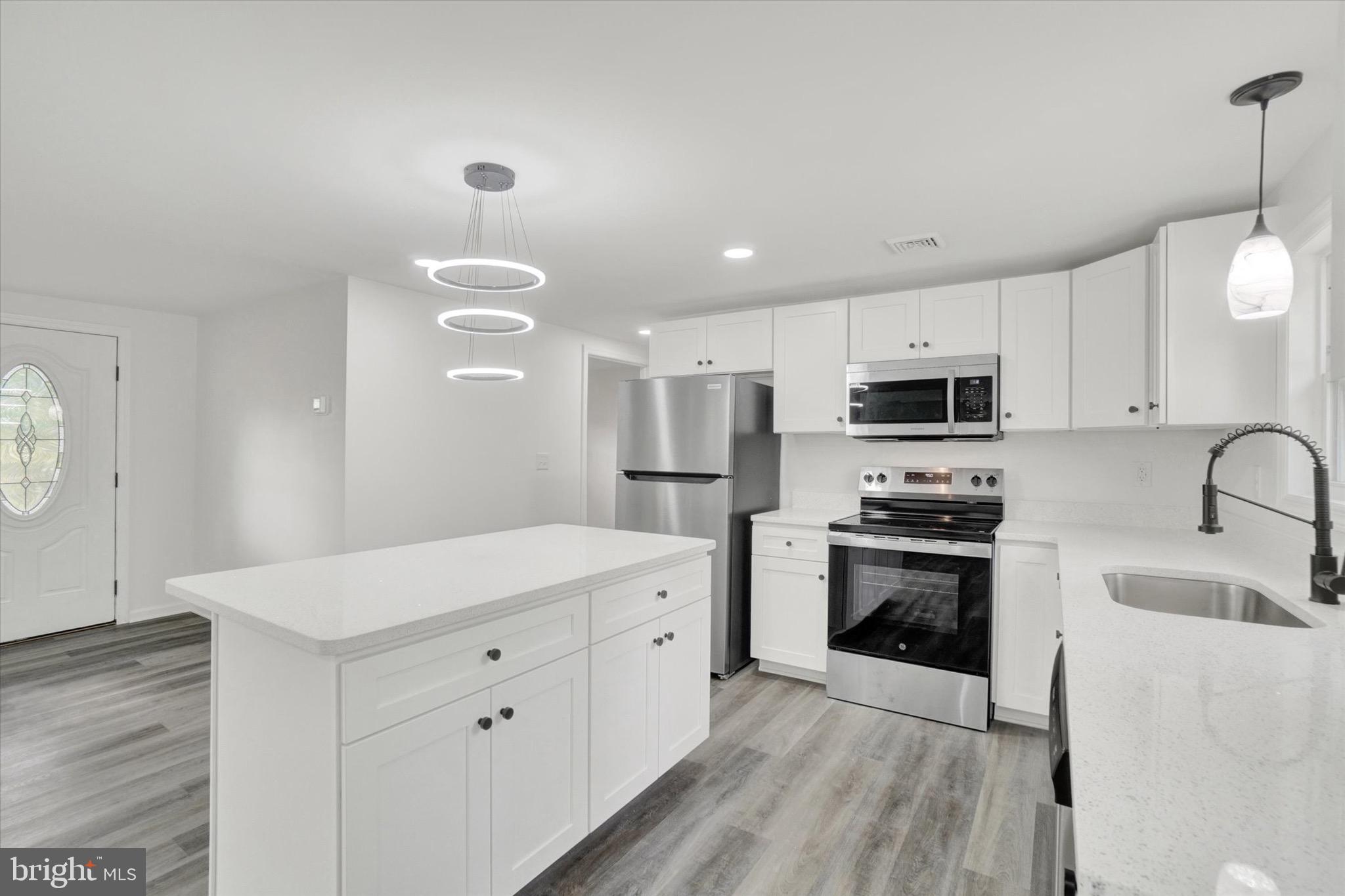 761 2nd Avenue Manchester, PA 17345 - Photo 7 of 29 a large white kitchen with stainless steel appliances granite countertop a stove a sink dishwasher and a refrigerator with wooden floor
