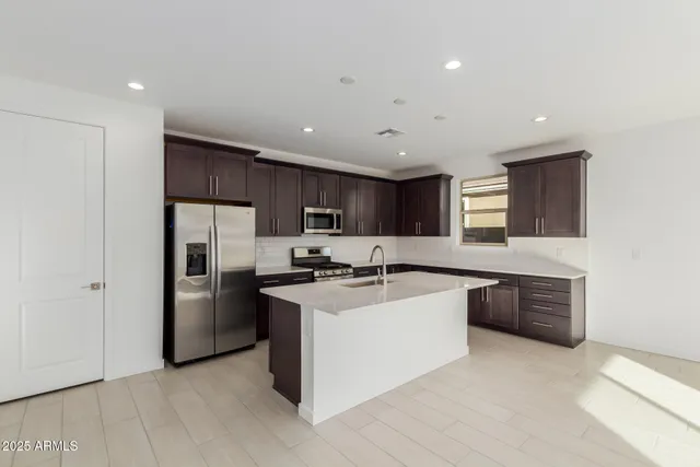 a kitchen with stainless steel appliances a sink stove and refrigerator