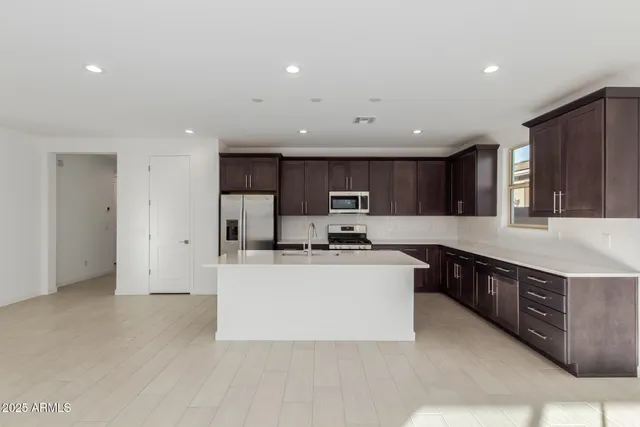 a kitchen with stainless steel appliances granite countertop a sink stove and refrigerator