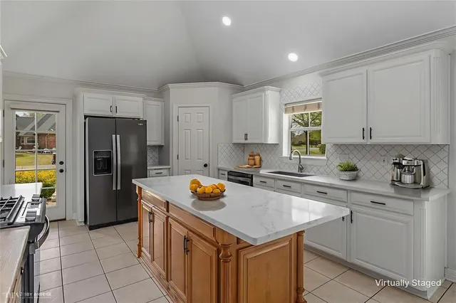 a kitchen with a sink a refrigerator and cabinets