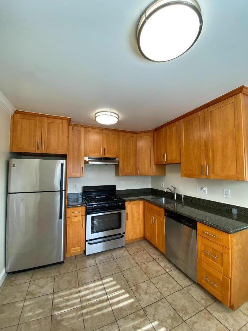 771 Pierce Road, Unit 6 Menlo Park, CA 94025 - Photo 2 of 5 a kitchen with granite countertop a stove a sink and a refrigerator