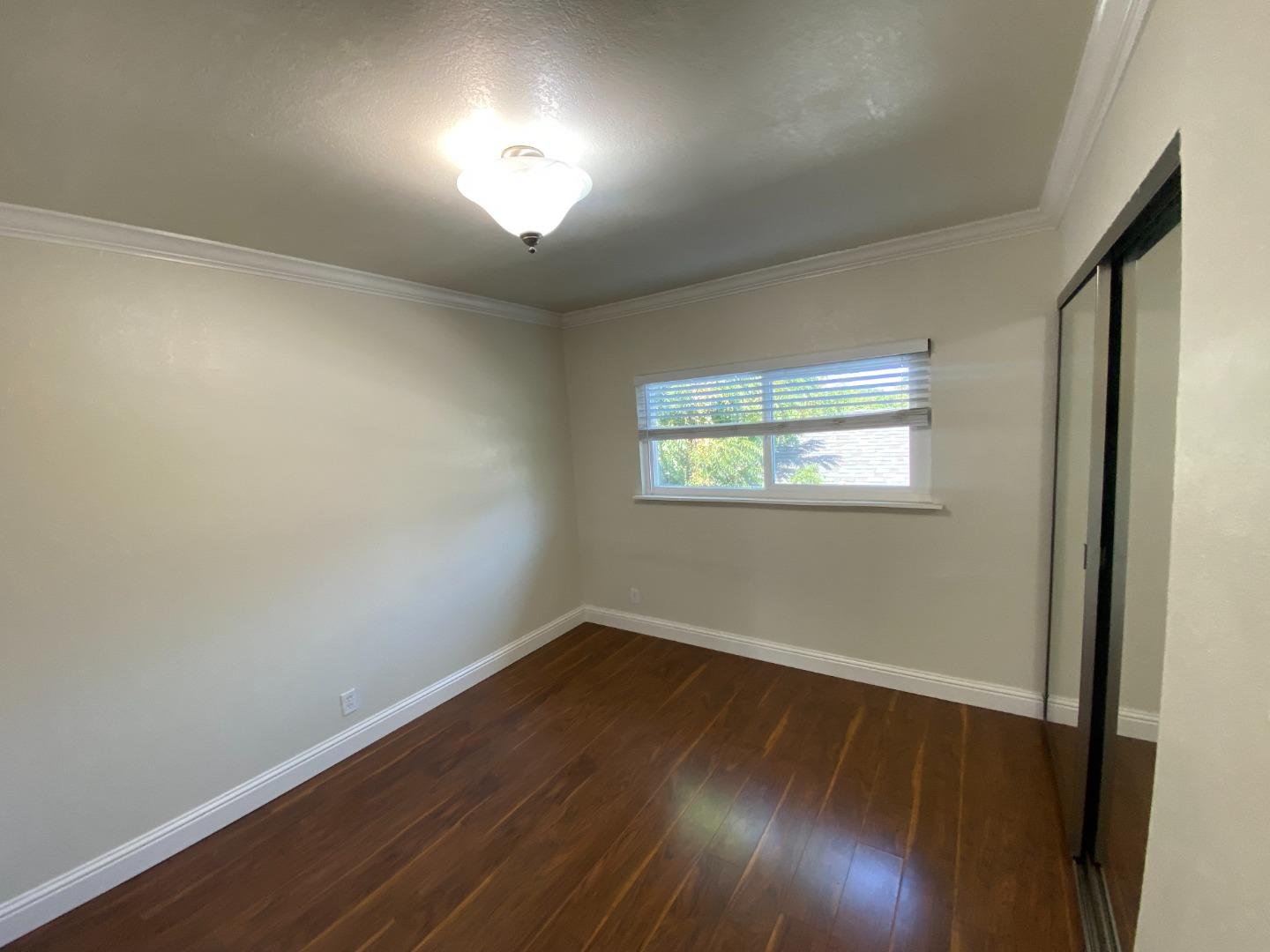 771 Pierce Road, Unit 6 Menlo Park, CA 94025 - Photo 4 of 5 an empty room with wooden floor and windows