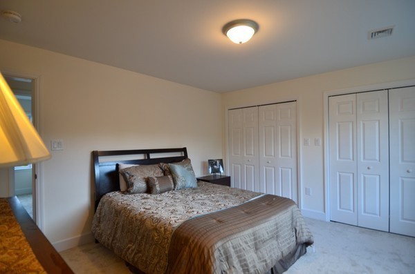 28 Harvard Road, Unit 1 Lancaster, MA 01523 - Photo 8 of 12 a bedroom with a bed and a night stand