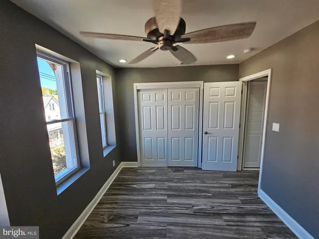 a view of a hallway with windows and chandelier fan