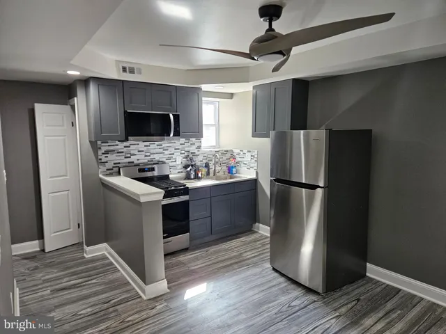 a kitchen with stainless steel appliances a refrigerator a stove a sink and a refrigerator