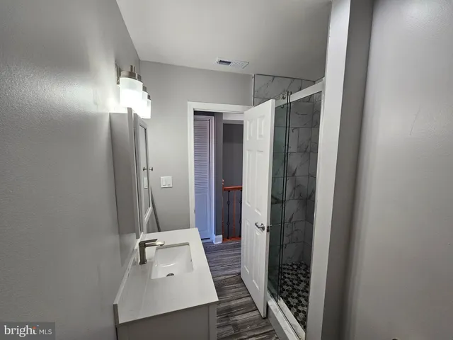 a bathroom with a sink a mirror and shower