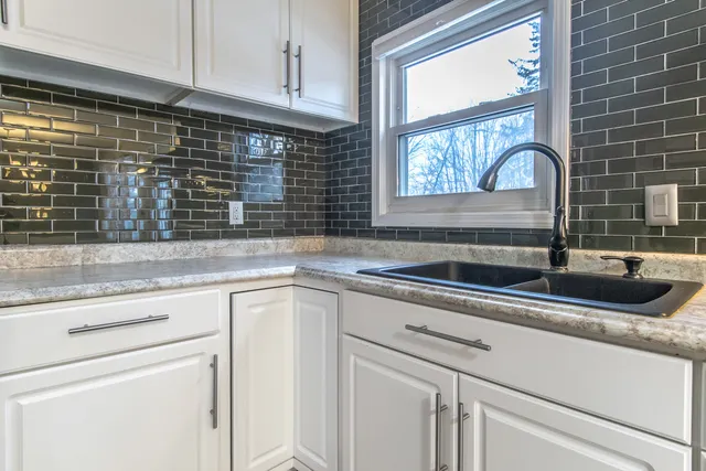 a kitchen with granite countertop a sink and a window