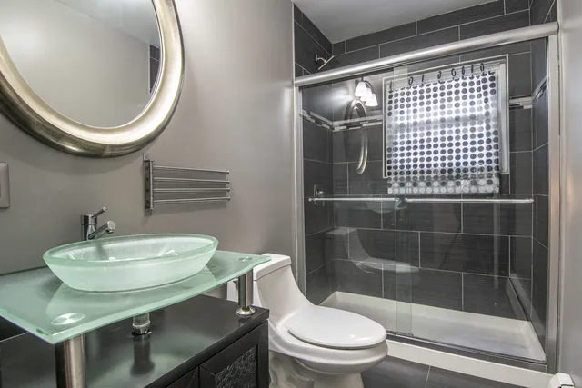 a bathroom with a sink a toilet and shower