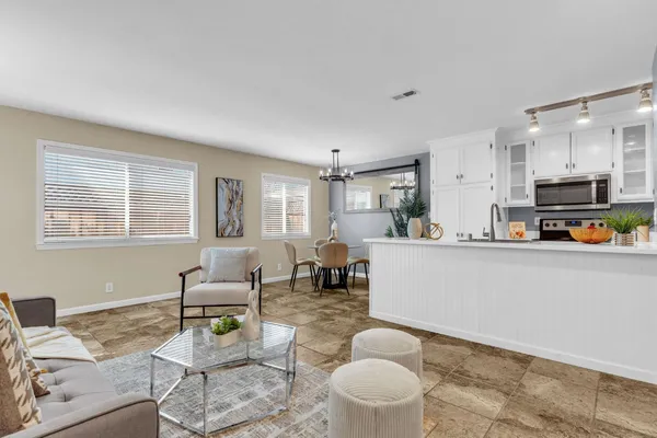 a living room with furniture and a dining table with kitchen view