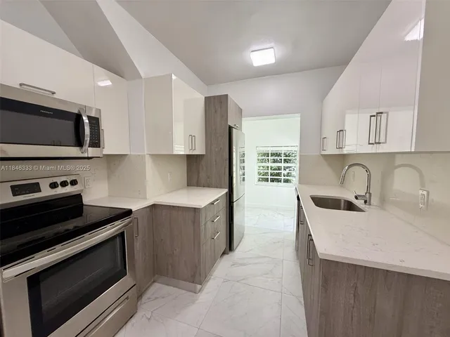 a kitchen with stainless steel appliances a stove sink microwave and cabinets