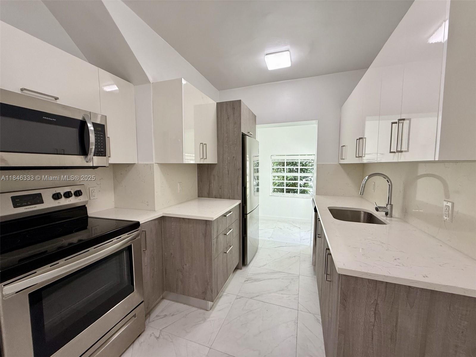 a kitchen with stainless steel appliances a stove sink microwave and cabinets