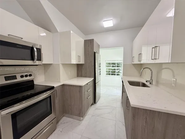a kitchen with stainless steel appliances a stove sink microwave and cabinets