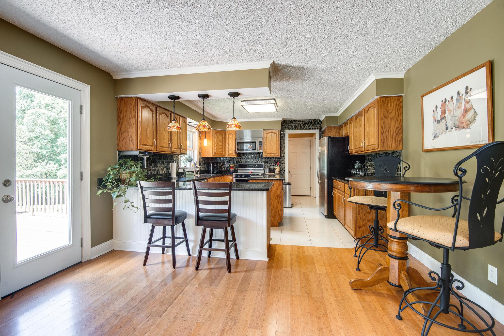 410 Baker Road Dickson, TN 37055 - Photo 14 of 30 a kitchen with stainless steel appliances kitchen island granite countertop a table and chairs in it
