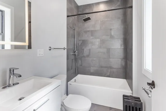 a bathroom with a sink a toilet a bathtub and shower