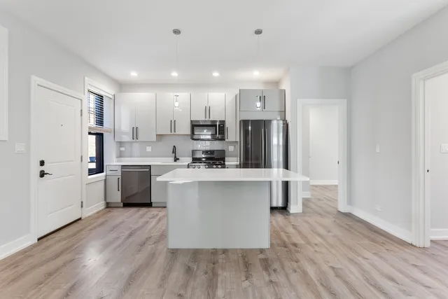 a kitchen with a sink a refrigerator and cabinets