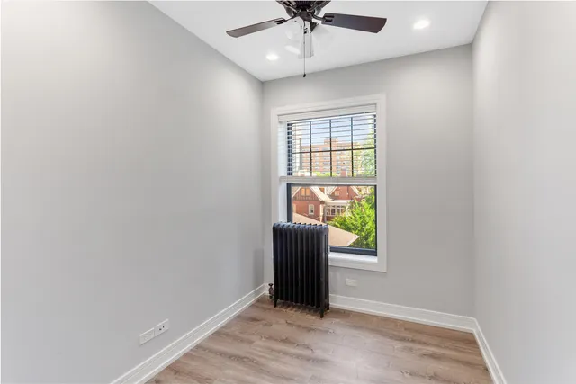 an empty room with window and a ceiling fan