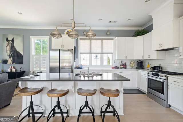 a kitchen with stainless steel appliances granite countertop a sink a stove and refrigerator