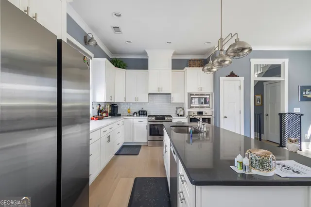 a kitchen with cabinets stainless steel appliances and sink
