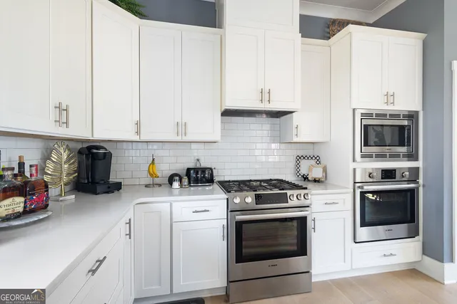 a kitchen with stainless steel appliances granite countertop a sink a stove and a refrigerator