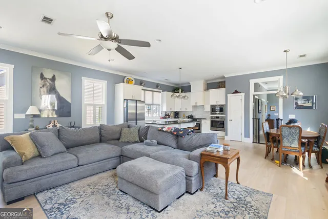 a dining room with furniture a chandelier and wooden floor