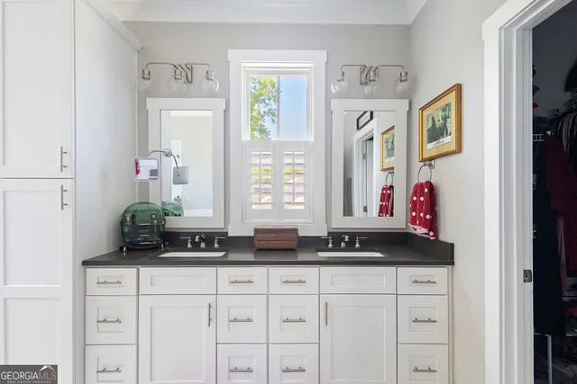 a bathroom with a granite countertop double vanity sink a mirror and a bathtub